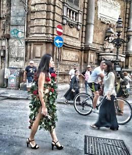 Vestita di sole rose in giro per le strade di Palermo